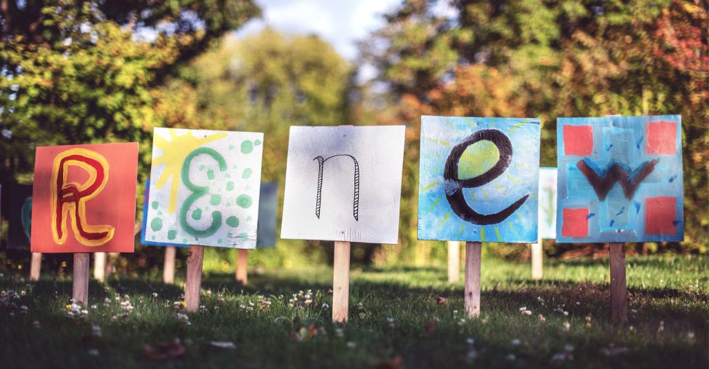 a colorful display of letters posted on sticks outside. 