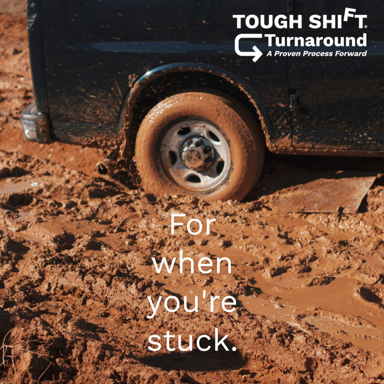 A truck stuck in the mud with the TOUGH SHIFT Turnaround logo