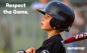 Young boy in baseball helmet and uniform with a bat looking out in amazement. The post carries the words, "Respect the Game"